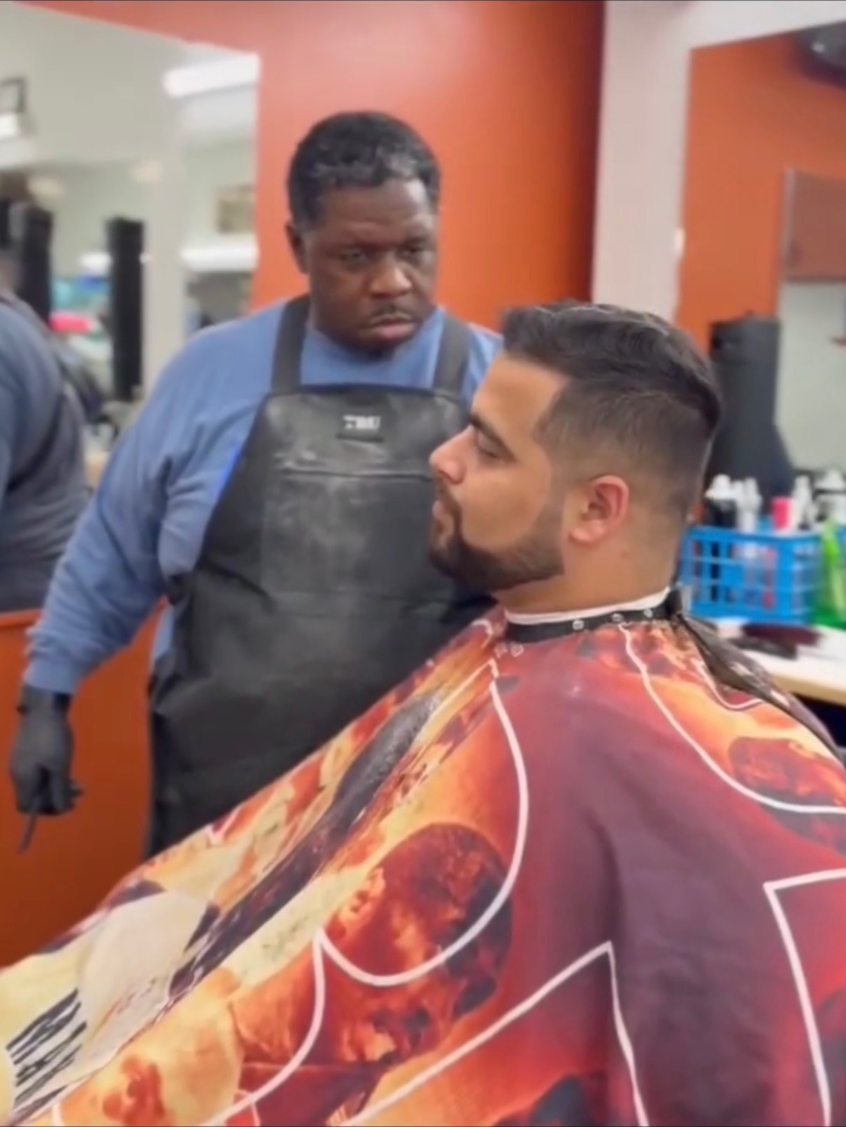 Master barber finishing a mid fade with a styled pompadour top