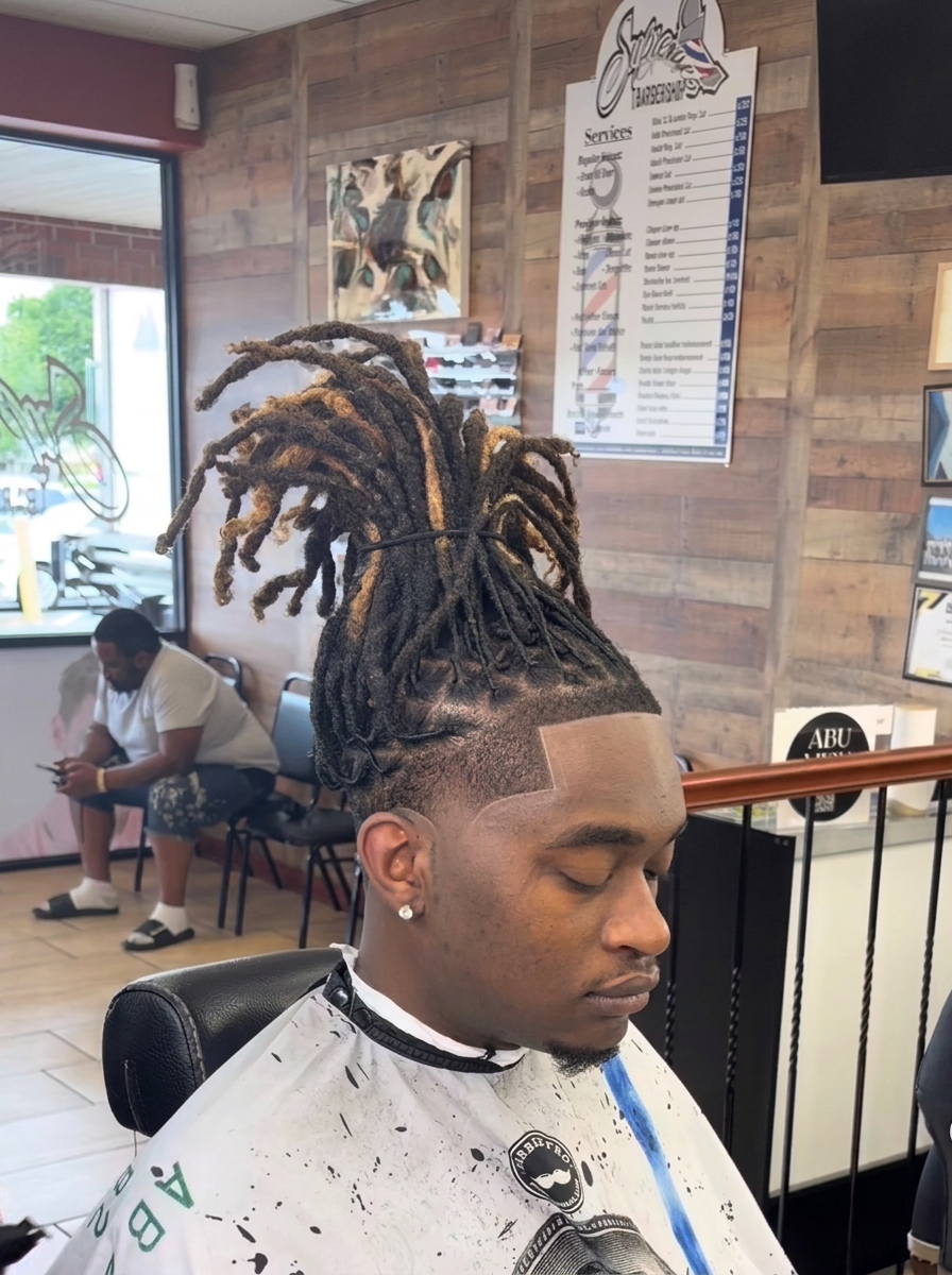 Fresh line-up and taper on a client with high-top locs at Supremes Barbershop