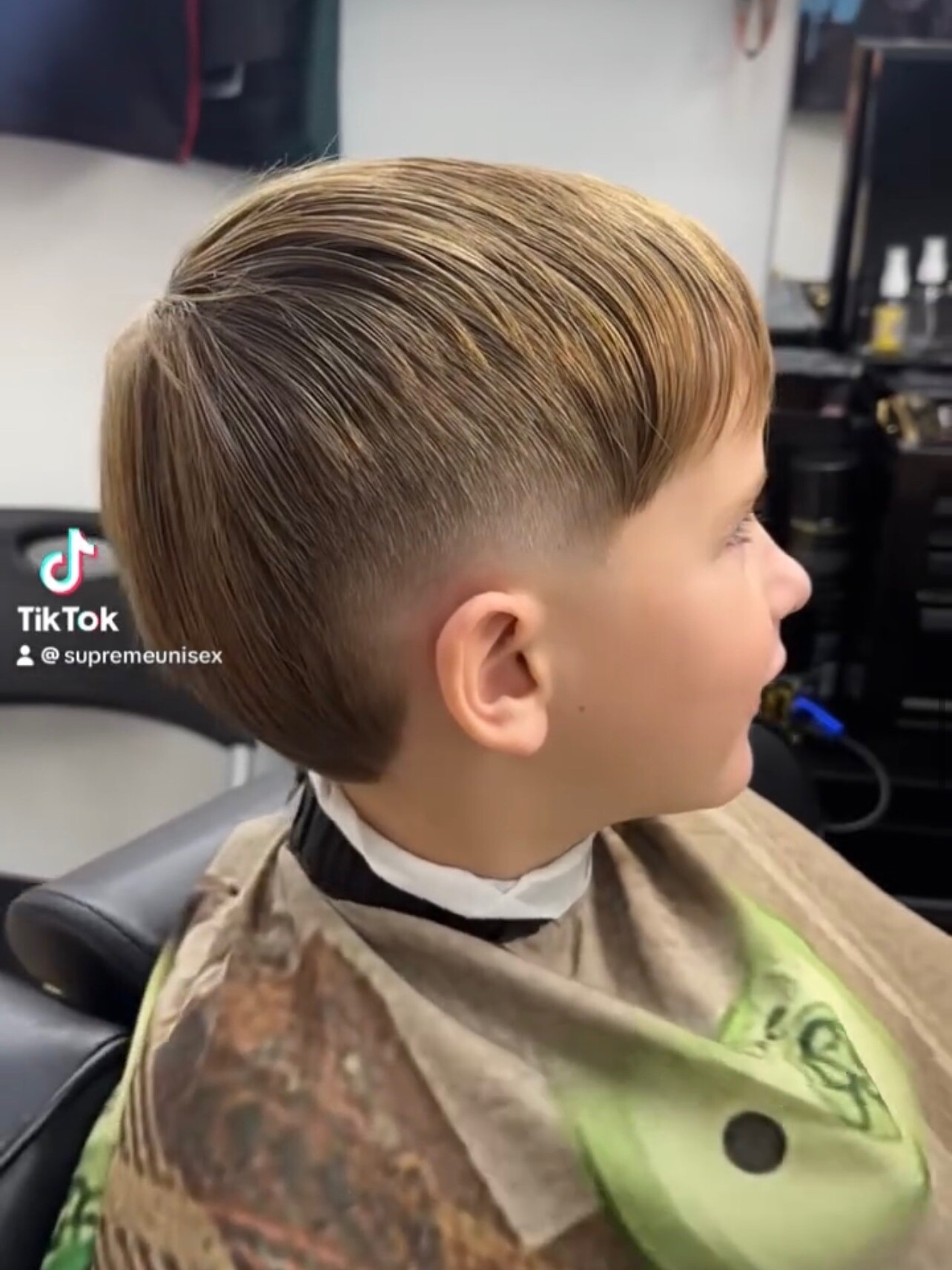 Kid's textured comb-over with a clean mid fade at Supremes Barbershop